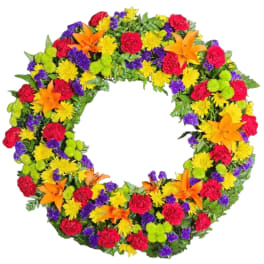 Colorful floral wreath with orange lilies, red carnations, and yellow and purple blooms