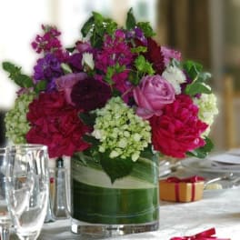 Mixed pink and purple flower arrangement in a glass vase