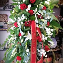 Large standing floral spray with red and white flowers on an easel