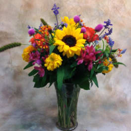 Mixed bouquet with a sunflower in a glass vase