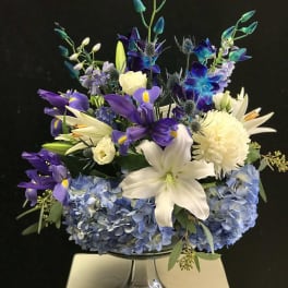 Blue and purple floral arrangement in a glass vase