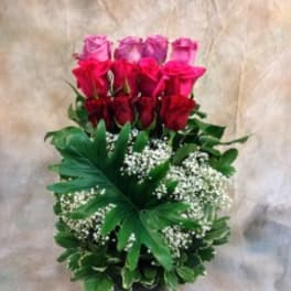 Tall bouquet of red and pink roses with white filler flowers