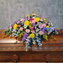 Colorful floral spray on a wooden casket