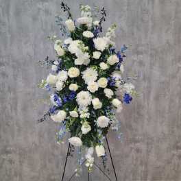 Tall white and blue floral standing spray on an easel