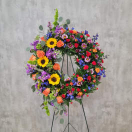 Large colorful floral wreath on a black stand