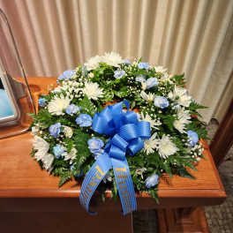 White and blue floral wreath with a blue ribbon bow
