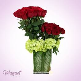 Red roses and green hydrangeas in a glass vase