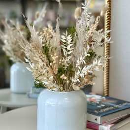 Dried floral arrangement in a pale blue vase