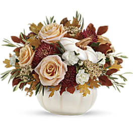 Peach roses and white flowers in a white pumpkin vase