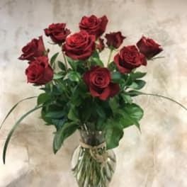 Red roses arranged in a clear glass vase