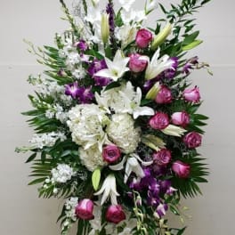 Tall standing floral spray with white lilies, pink roses, and purple orchids