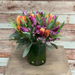 Colorful tulip bouquet in a green glass vase