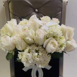 White rose bouquet in a black box with a pearl Chanel logo