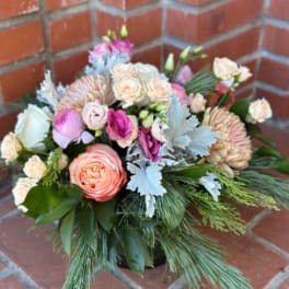 Mixed bouquet of pink and peach flowers with greenery