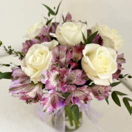 Bouquet of white roses and pink alstroemeria in a glass vase
