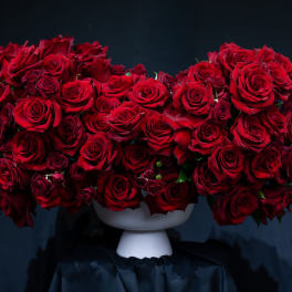 Large arrangement of red roses in a white pedestal vase