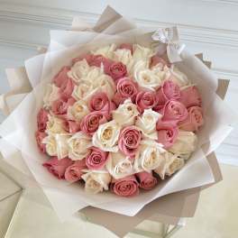 Bouquet of pink and white roses wrapped in layered paper