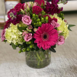 Bouquet of pink and magenta flowers in a clear glass vase