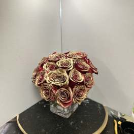 Bouquet of red and gold roses in a clear square vase