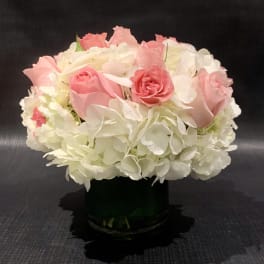Pink roses and white hydrangeas in a dark vase