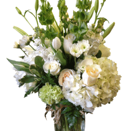 White floral arrangement in a glass vase with lilies and roses