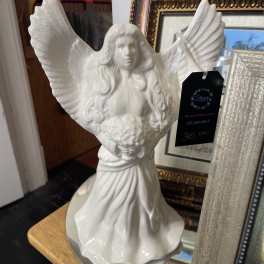 White angel figurine with outstretched wings on a table