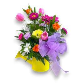 Mixed bouquet in a yellow watering can with a purple bow