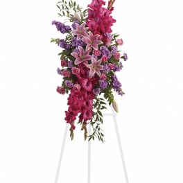 Tall standing floral spray with pink lilies, roses, and purple flowers