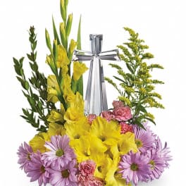 Yellow and lavender floral arrangement with a silver cross centerpiece