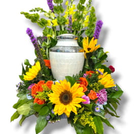 Colorful floral urn arrangement with sunflowers and orange roses