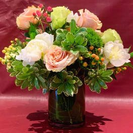 Pink and white roses arranged in a dark glass vase