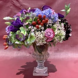 Mixed bouquet in a clear glass vase with purple, pink, and white flowers
