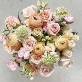 Bouquet of blush and peach roses with pale green blooms