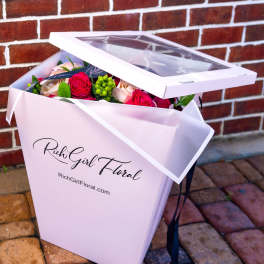 Pink gift box with roses and greenery inside