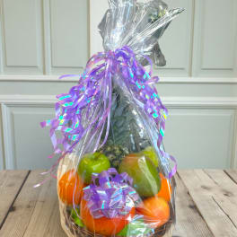 Wrapped fruit basket with purple ribbon and assorted fruit