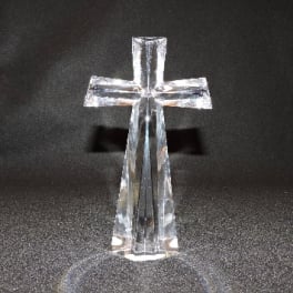 Clear glass cross ornament on a dark background