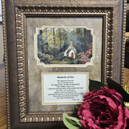 Framed memorial plaque with a pink flower accent