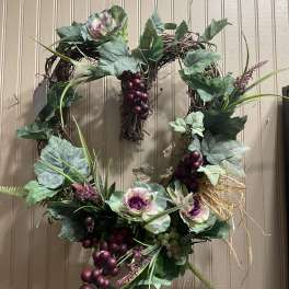 Decorative grapevine wreath with faux cabbage roses and purple grapes