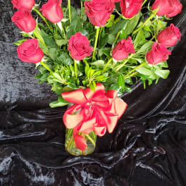 Bouquet of red roses in a glass vase with a red ribbon
