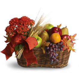 Fruit basket with apples, pears, grapes, and a red bow