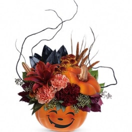 Halloween bouquet in a smiling pumpkin container with orange and red flowers
