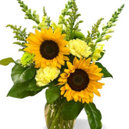 Sunflowers and pale yellow flowers in a glass vase