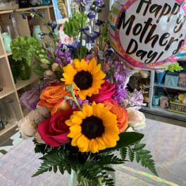 Mixed bouquet in a glass vase with a Mother's Day balloon