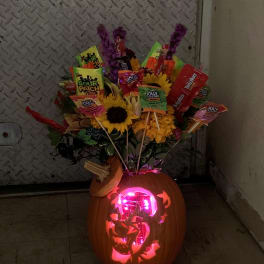 Carved pumpkin with candy bouquet and sunflowers
