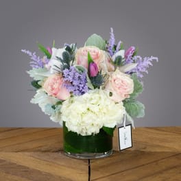 Pink roses and white hydrangeas in a glass vase with lavender accents