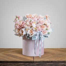 Blush rose bouquet in a pink hat box with ribbon tails