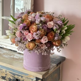 Large pastel bouquet of roses and tulips in a pink hatbox