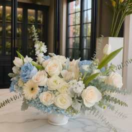 White and blue floral arrangement in a white vase