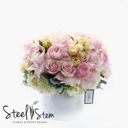 Pink and cream rose bouquet in a white vase