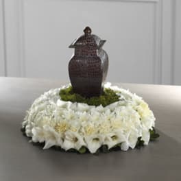 White floral wreath with a dark decorative urn in the center